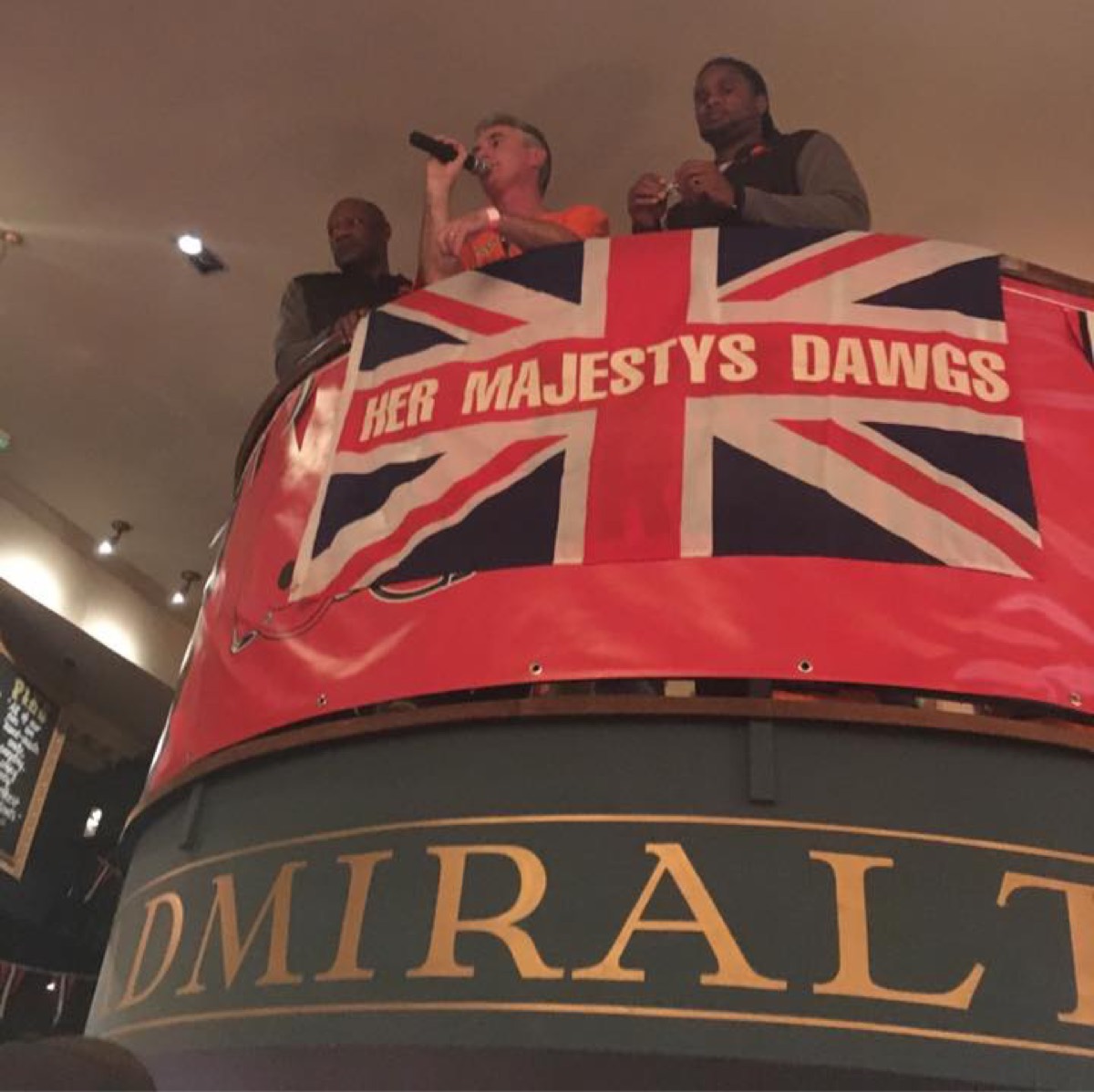 Bulldawgs members with the Her Majesty's Dawgs flag at the Admiralty pub in London